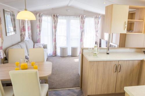 a kitchen and living room with a table and chairs at Barmouth Bay Holiday Park in Barmouth