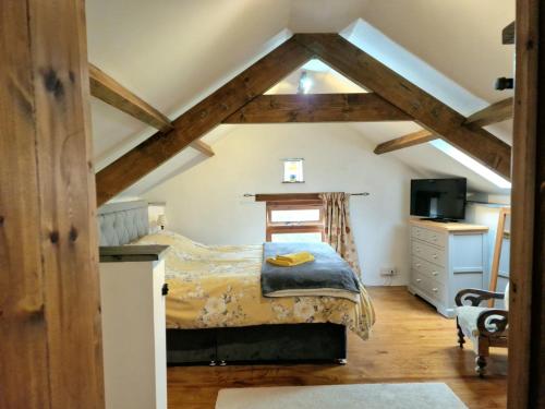 a bedroom with a bed in a attic at LYDONIA BARN in Lydford