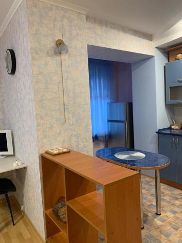 een kleine keuken met een tafel en een koelkast bij Затишна квартира на бульварі Свободи 49 ЖОВТІ ВОДИ in Zhovti Vody