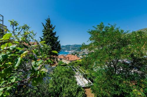 a view of a city from behind some trees at Apartments Dub in Dubrovnik