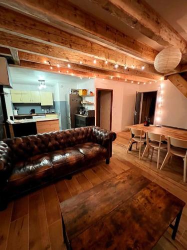 un salon avec un canapé en cuir et une table dans l'établissement Blancs Vercors, appartement-gîte, à Lans-en-Vercors