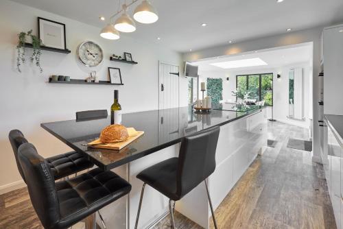 a kitchen with a black counter and black chairs at Host & Stay - The Lodge in Warkworth