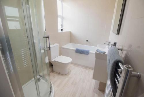 een witte badkamer met een toilet en een douche bij The Courtyard, 30 Seconds to Sea By Air Premier in Seaford