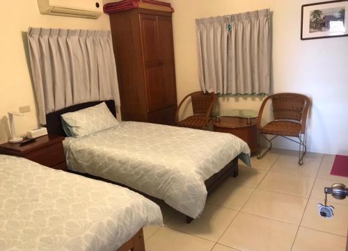 a hotel room with two beds and a table and chairs at Nantang No. 1 in Lieyu