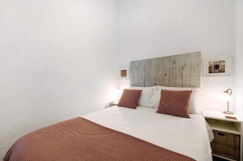 um quarto com uma grande cama branca e 2 almofadas em Casa Doce em Silves