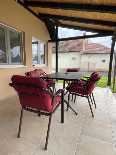a patio with a table and chairs on a patio at Katarina Rooms in Novi Kneževac