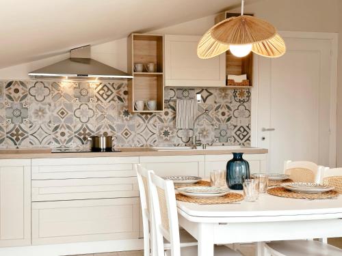 una cocina con mesa blanca y sillas y una cocina con en Tabbihome Apartments - Costa dei Trabocchi, en Paglieta