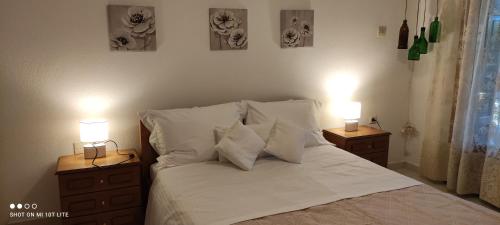 a bed with two night stands with two lamps on them at Colors Apartments Pilio in Afissos