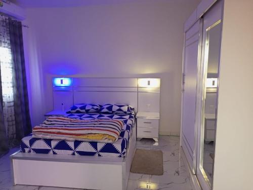 a bedroom with a bed with blue lights on it at Mamou hlm grang yoff in Dakar