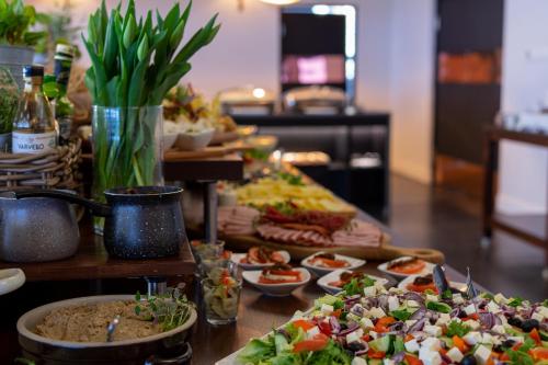 ミエンジボジェにあるFala by Marena Wellness & Spaのテーブルの上にたくさんの料理が並んだビュッフェ