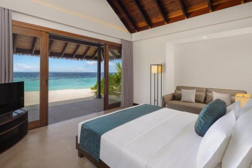 Schlafzimmer mit einem Bett und Meerblick in der Unterkunft NOOE Maldives Kunaavashi in Fulidhoo