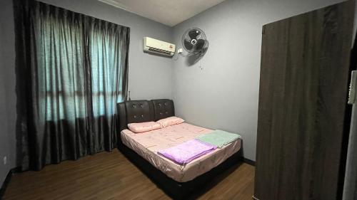 a small bedroom with a bed and a fan at Sandakan Homestay IJM Condo 3R2B Serenity Lodge 明悦之居 - 7 Pax in Bandar Indah