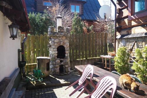 un patio con tavolo, sedie e camino di Pokoje gościnne u Ewy a Zakopane