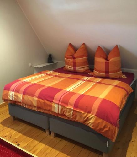 a bedroom with a bed with colorful sheets and pillows at Ferienwohnung-Am-Sternbusch in Hau