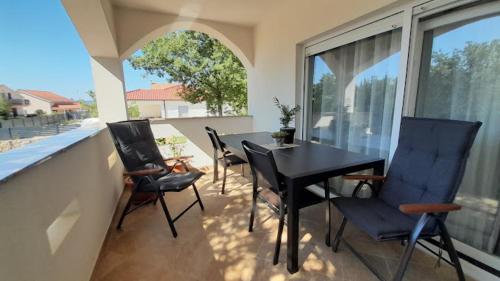 comedor con mesa y sillas y balcón en Apartments & Room Danijel en Pinezici
