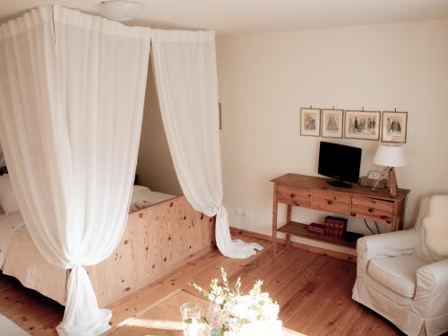 a living room with a bed with white curtains at Großkandlerhaus in Unterdambach