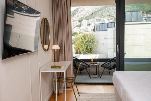 una camera d'albergo con letto, tavolo e sedie di City Residences a Dubrovnik