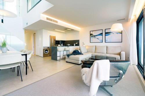 a living room with a couch and a table at Luxury Duplex Penthouse Denia in Denia