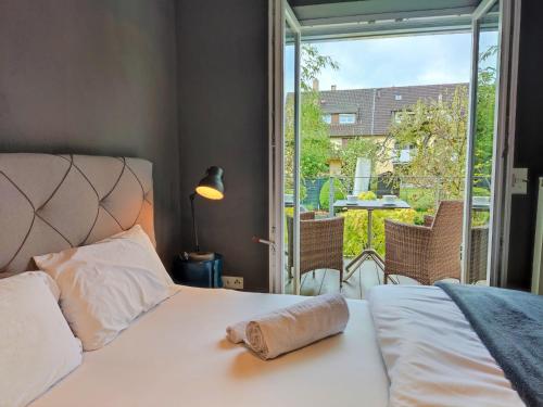 - une chambre avec un lit et une vue sur une terrasse dans l'établissement Zen Apartment - spacious - garden - kitchen, à Karlsruhe