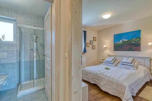 Schlafzimmer mit einem Kingsize-Bett und einer Dusche in der Unterkunft Apartments ApArt Bled in Bled
