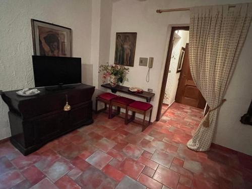 a living room with a television and a tiled floor at Residence La Villa in Montescudaio