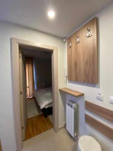 een kamer met een slaapkamer met een bed en een spiegel bij Miris tisine in Zlatibor