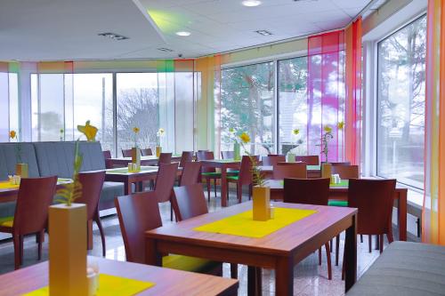a dining room with tables and chairs and windows at Fra Mare Thalasso Spa in Haapsalu