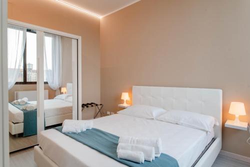 um quarto com uma grande cama branca e um espelho em Regina Apartment em Turim