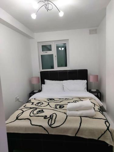 a bedroom with a black and white bed with two lamps at Home Away Barking in Barking