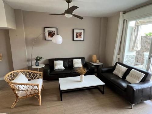 sala de estar con sofá negro y mesa en Costa Ballena - Duplex Playa Lar Beach House, en Costa Ballena
