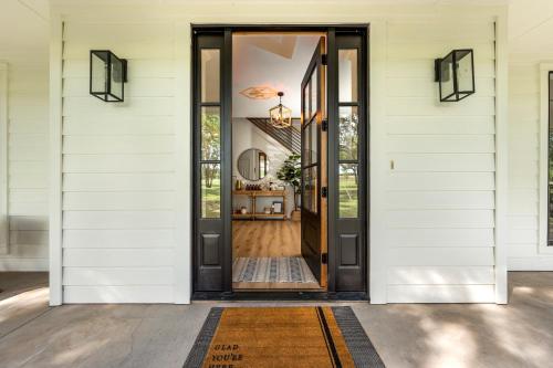 an open door on a house with a rug at 50 Acre Countryside Haven With Hiking Trails, Fossils, Pickleball Court, Basketball, Arcade, In-Ground Trampoline, Pool and Jacuzzi residence in Glen Rose