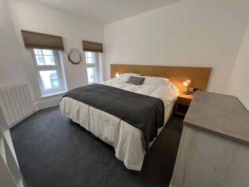 um quarto com uma cama com um computador portátil em Charming 1-Bed & balcony Flat in Merthyr Tydfil em Merthyr Tydfil