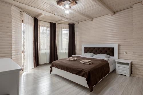 a bedroom with a large bed with two towels on it at Villa Morishka & SPA in Bukovel