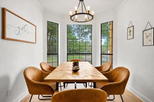 a dining room with a wooden table and chairs at 50 Acre Countryside Haven With Hiking Trails, Fossils, Pickleball Court, Basketball, Arcade, In-Ground Trampoline, Pool and Jacuzzi residence in Glen Rose