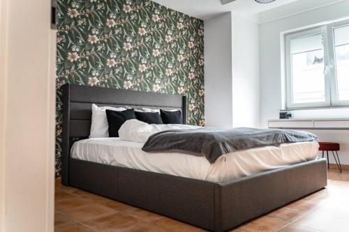 Un dormitorio con una cama con una pared de acento floral en Moderne Wohnung im Herzen Offenbachs en Offenbach