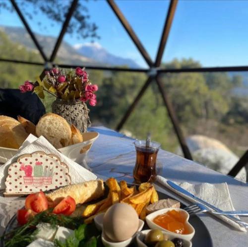 a table with a plate of food on a table at EvergreenGlamping in Kumluca