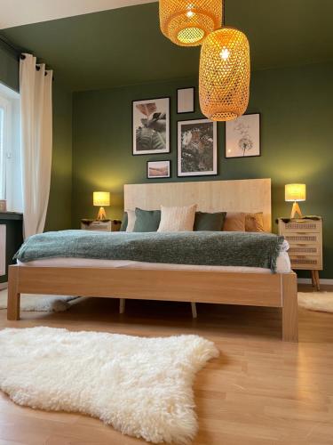 Un dormitorio con una cama grande y una pared verde en *NEU* Extravagantes Eifelhaus am Nürburgring, en Mannebach