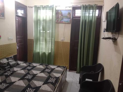 1 dormitorio con 1 cama, cortinas verdes y TV en OYO Home Utsav Regency, en Manesar