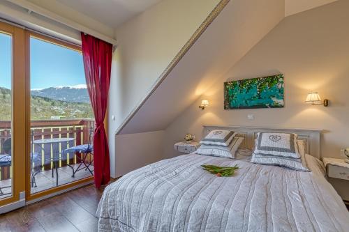 a bedroom with a bed and a balcony at Apartments ApArt Bled in Bled