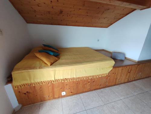 a bed in a room with a wooden floor at Dario studio apartman in Kukljica
