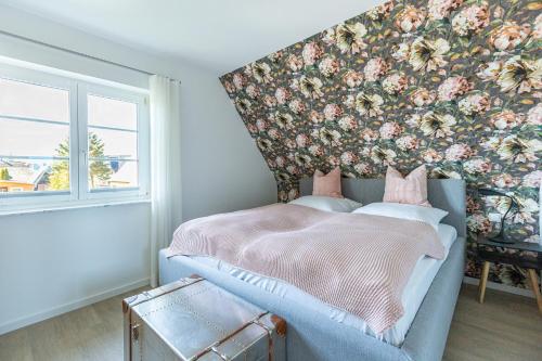 a bedroom with a bed with a floral wall at Lieblingsplatz in Born