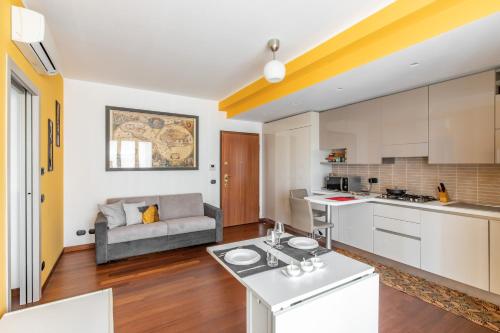 cocina y sala de estar con sofá en Duke Apartment - San Donato Milanese - by Host4U, en San Donato Milanese