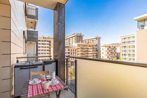 un balcón con una mesa con comida y bebidas. en Duke Apartment - San Donato Milanese - by Host4U, en San Donato Milanese