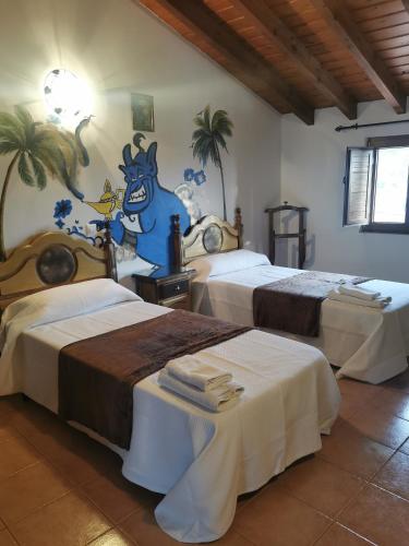 two beds in a room with palm trees on the wall at Posada La Maza in Arnuero