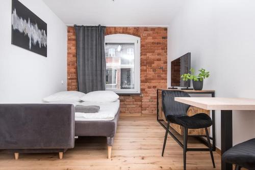 ein Wohnzimmer mit einem Bett und einem Tisch in der Unterkunft Apartament Zwycięstwa in Gliwice