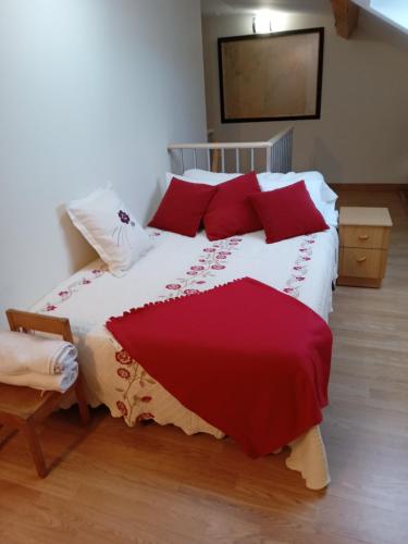 a bedroom with a large bed with red pillows at Casa Adrián in Sabardes