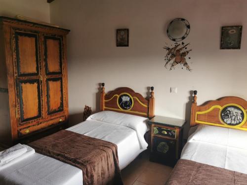 a bedroom with two beds and a table and a window at Posada la Maza in Arnuero