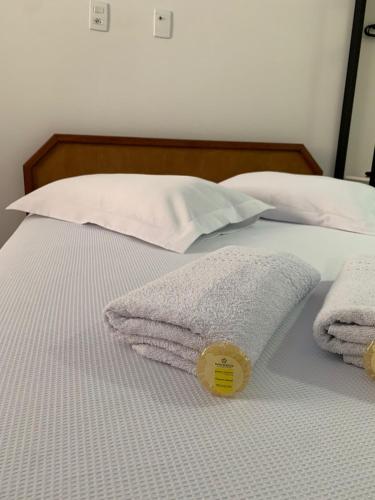 a bed with two towels and two pillows on it at HOTEL POUSADA POR DO SOL in Pato Branco