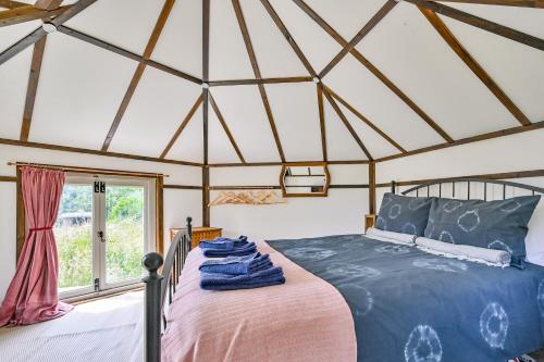 1 dormitorio con cama y ventana en Lower Marsh Farm in Cornwall, en Saltash