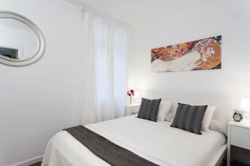 um quarto branco com uma cama branca e um espelho em Flat in Bacelona Center em Barcelona